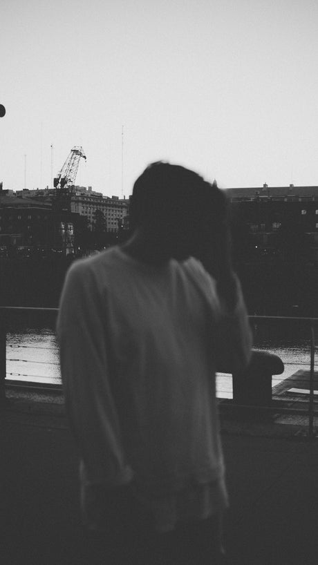 man in white shirt standing near body of water during daytime