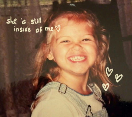 A young girl with a big smile and hearts.