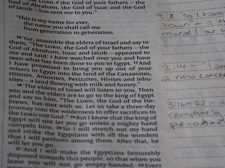 Close-up of an open bible with handwritten notes.